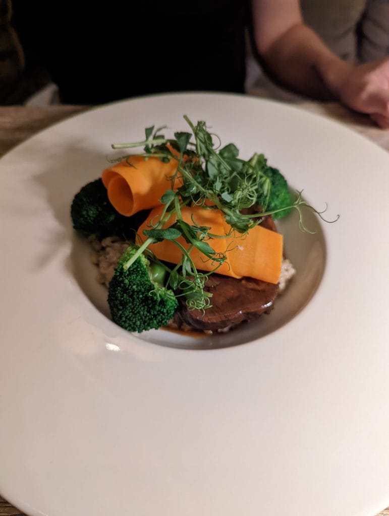 Entrée créative à base de brocolis, carottes croquantes et herbes fraîches, illustrant la finesse de la cuisine du restaurant Szara Gęś w Kuchni à Cracovie.