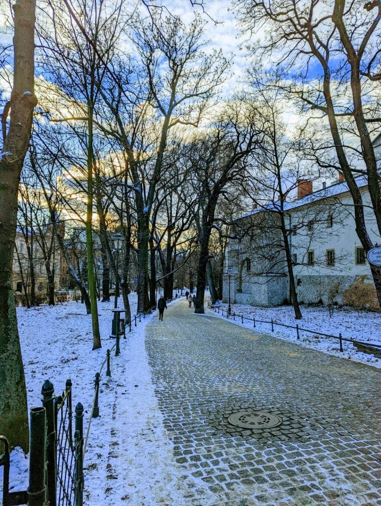 Le parc des Planty sous la neige en hiver, une balade charmante le long des murs de la vieille ville à inclure dans votre itinéraire pour visiter Cracovie en 3 jours.