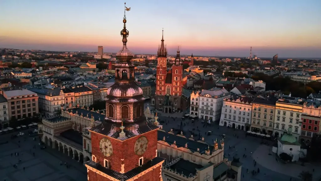 Vue panoramique de la place du marché de Cracovie au coucher du soleil, une étape incontournable de votre itinéraire pour visiter Cracovie en 4 jours.