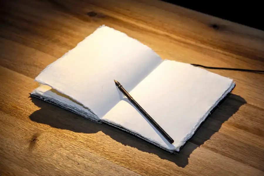 astuces-conseils-utiles-cracovie Carnet de notes ouvert, stylo et tasse de café sur une table, symbolisant les conseils pratiques et les infos utiles pour un séjour à cracovie