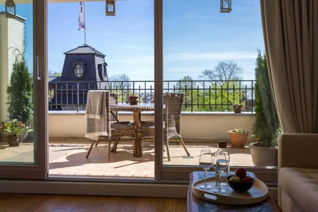 Grand salon et balcon du Fragola Apartments, idéal pour loger en famille nombreuse à Cracovie